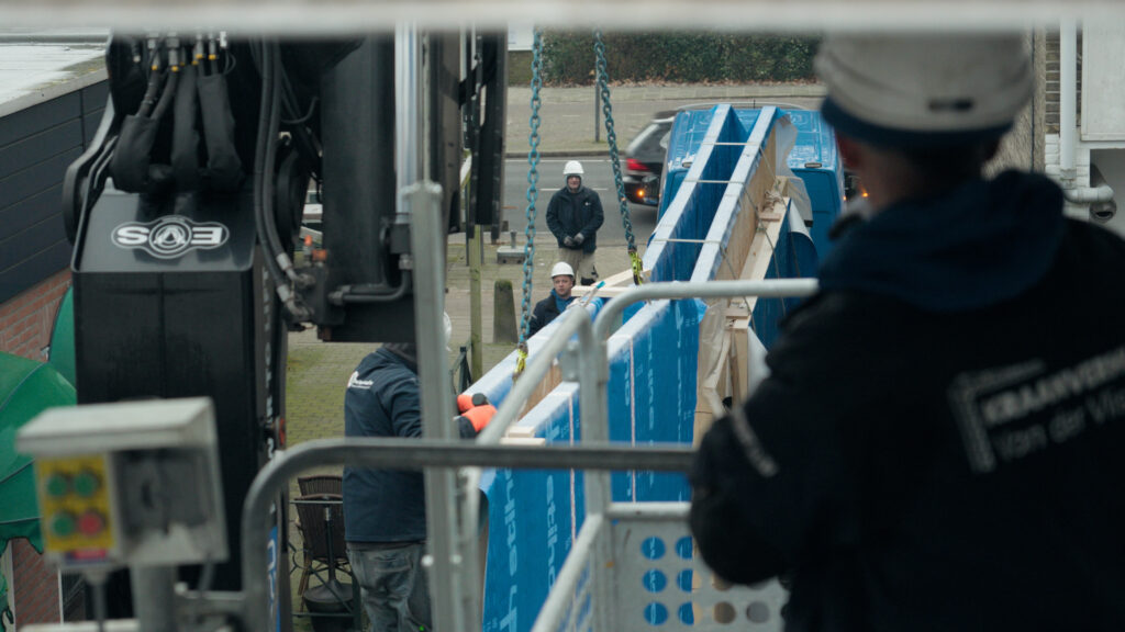 Vakmensen voeren nauwkeurig werkzaamheden uit langs een drukke doorgaande weg.